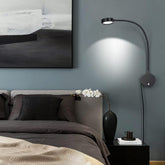 Modern bedroom with a bed, wall lamp, and abstract art on the wall.